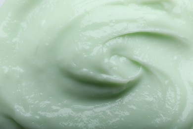 Closeup view of light green body cream as background