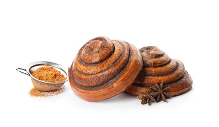 Freshly baked cinnamon rolls with ingredients on white background