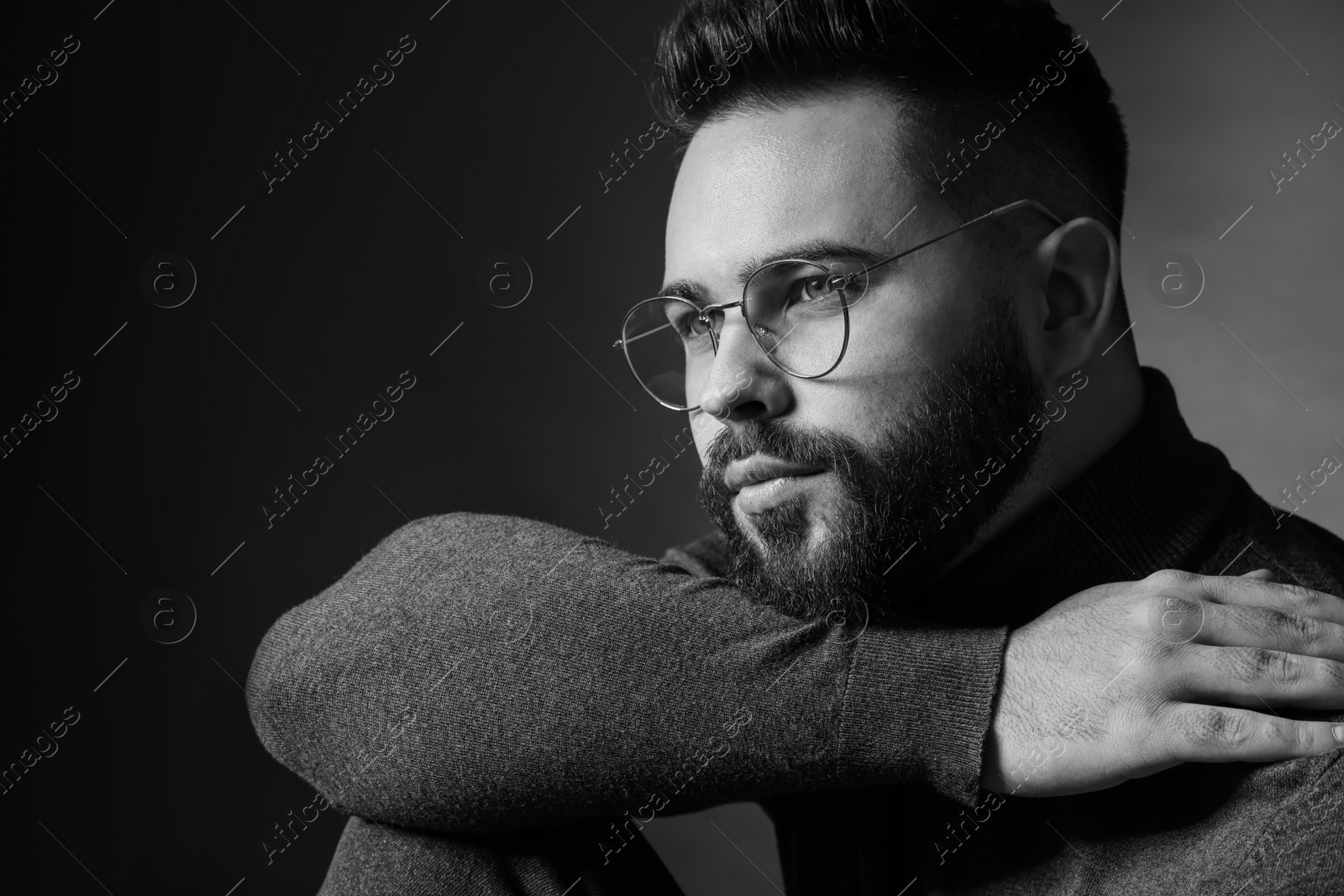 Photo of Portrait of handsome bearded man on dark background. Black and white effect