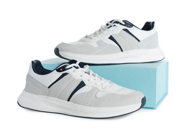 Pair of stylish sport shoes and turquoise box on white background