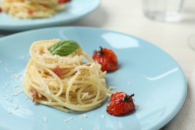 Photo of Tasty spaghetti with tomatoes and cheese on table, closeup. Exquisite presentation of pasta dish