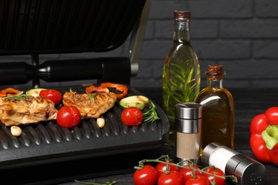 Electric grill with different products on black table