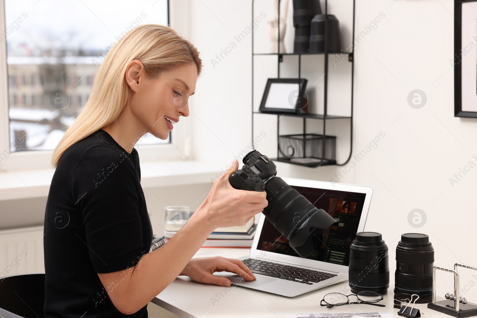 Photo of Professional photographer with digital camera at table in office