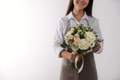 Photo of Florist holding beautiful wedding bouquet on white background, closeup