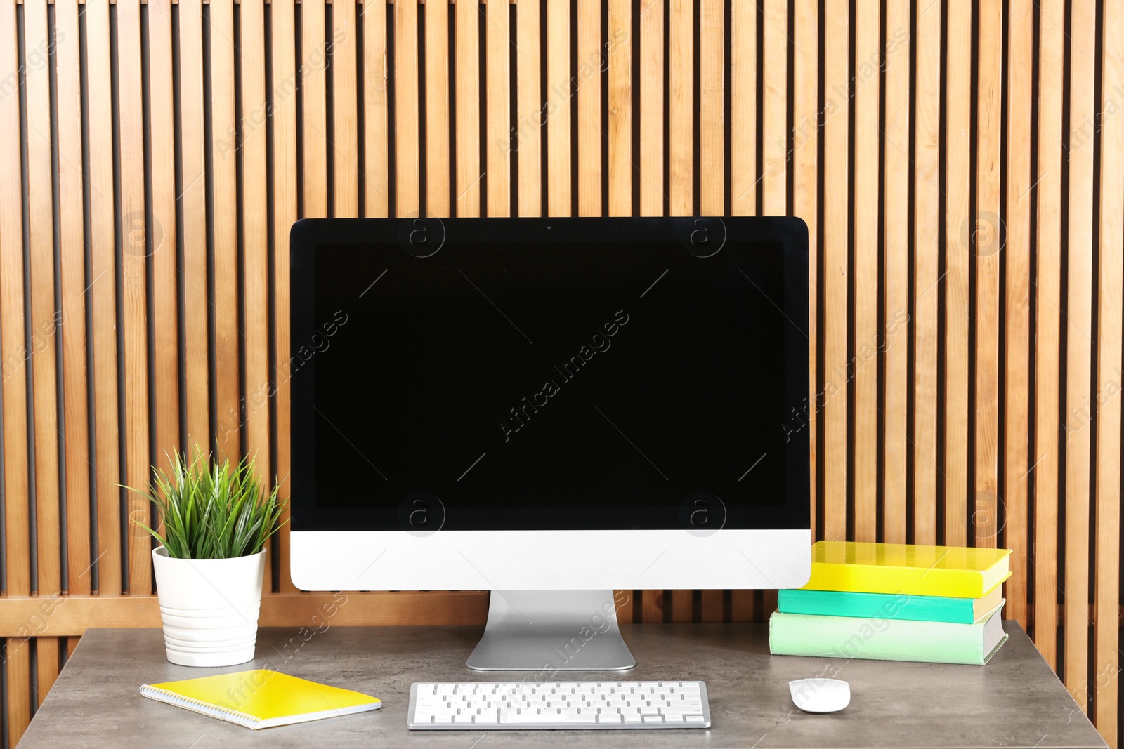 Photo of Computer with blank monitor at table indoors. Mock up for design