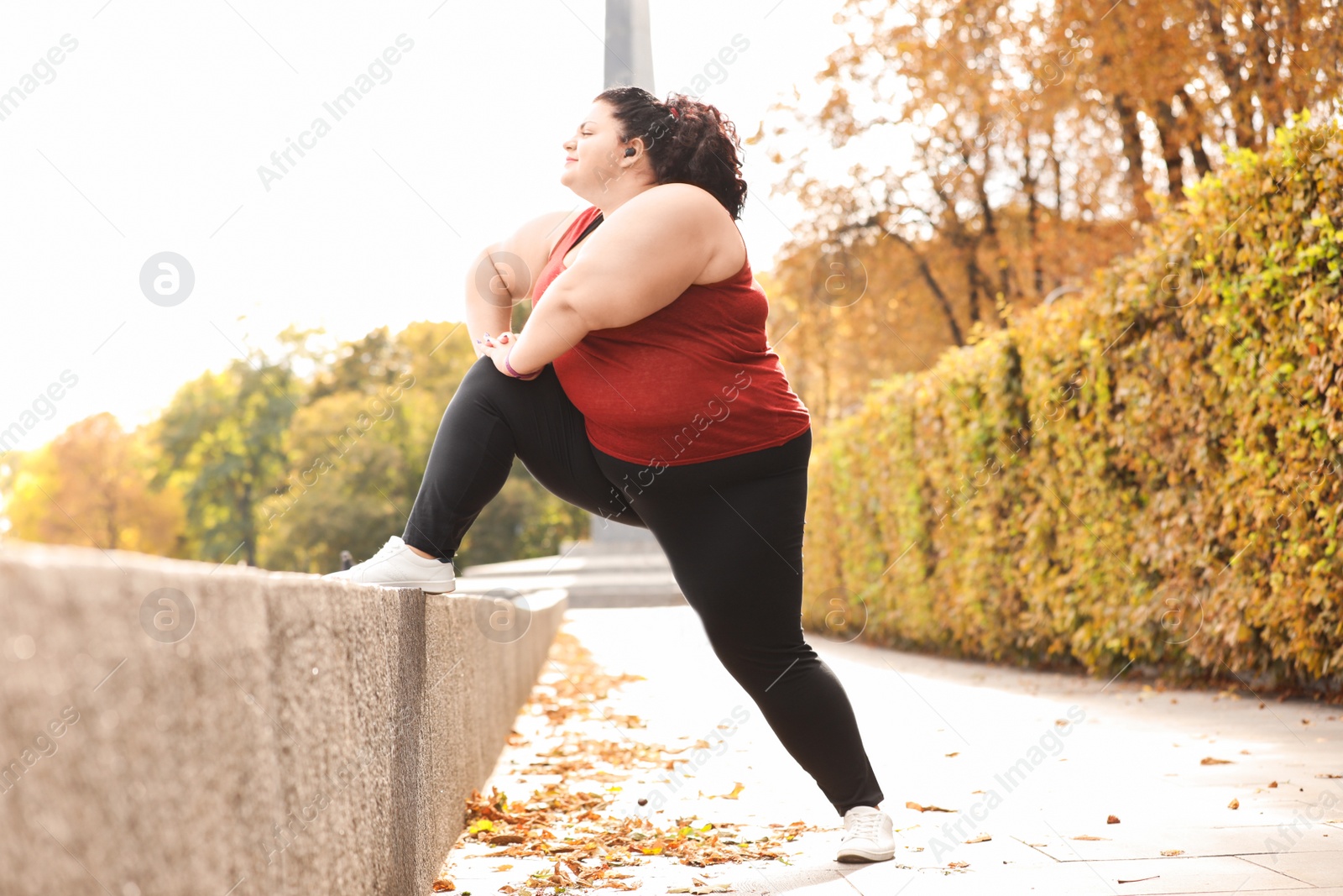 Photo of Beautiful overweight woman doing sport exercises in park