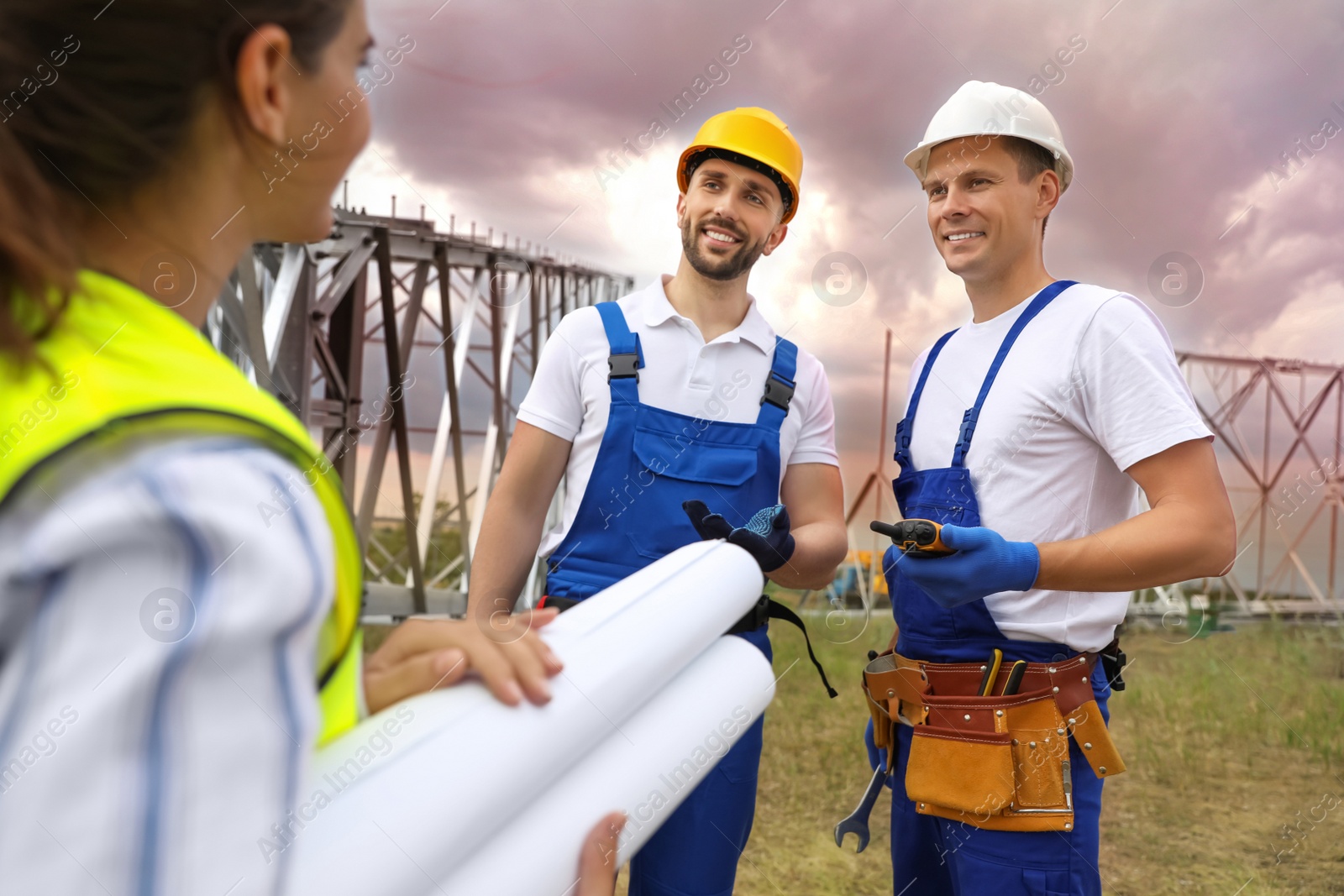 Photo of Professional engineers working on installation of electrical substation outdoors