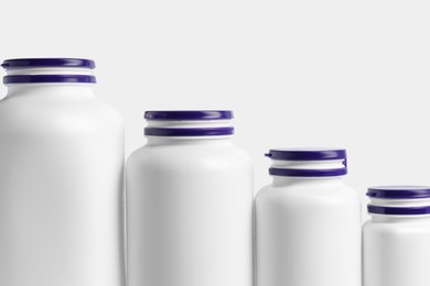 Row of different plastic medicine bottles on white background. Medicament