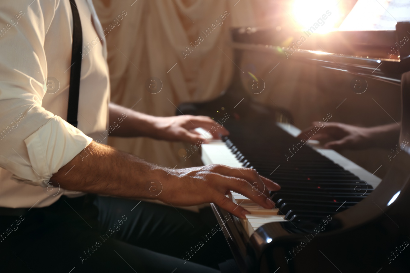 Photo of Man playing piano indoors, closeup. Talented musician