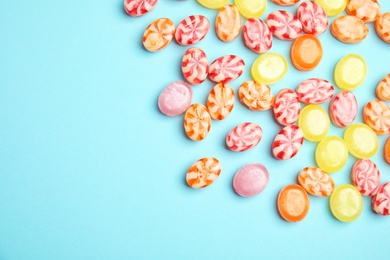 Flat lay composition with delicious colorful candies and space for text on color background