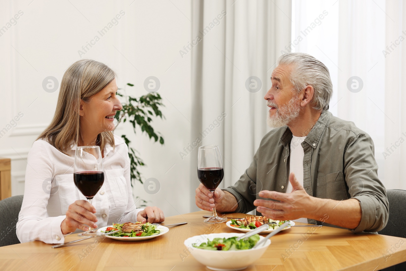 Photo of Happy senior couple having romantic dinner at home