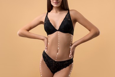 Woman showing her beautiful figure on dark beige background, closeup. Cosmetic treatment lines on her body