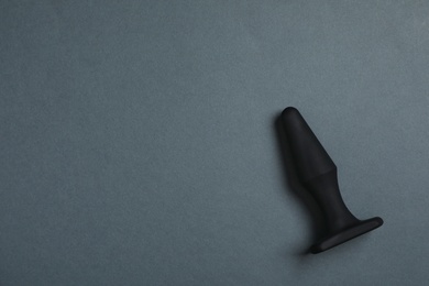 Black anal plug on dark background, top view with space for text. Sex toy