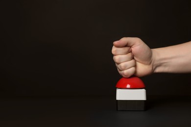 Photo of Man pressing red button of nuclear weapon at black background, closeup with space for text. War concept
