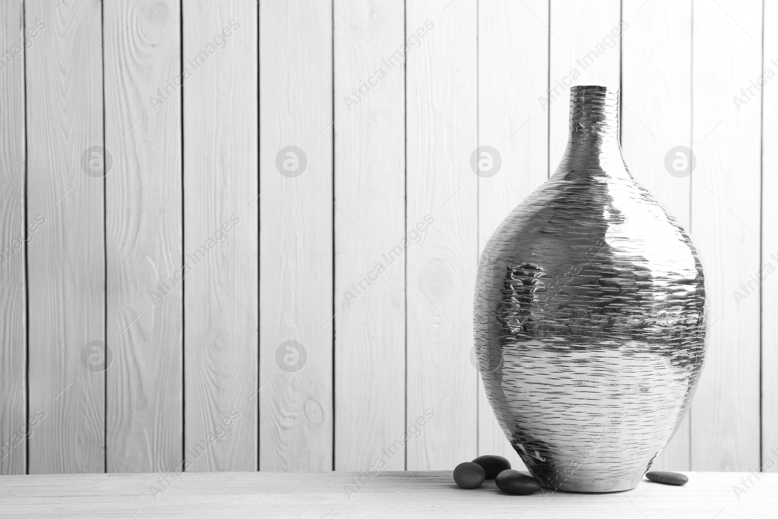Photo of Stylish silver ceramic vase on white wooden table. Space for text