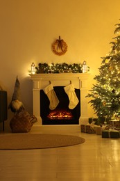 Stylish fireplace with Christmas decorations in cosy room