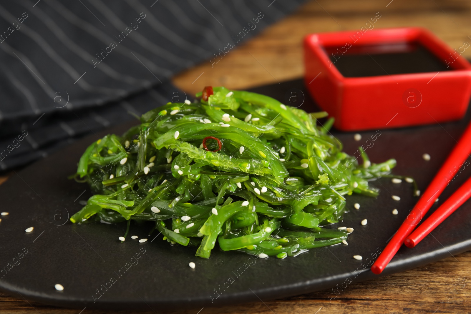 Photo of Japanese seaweed salad served on table, closeup