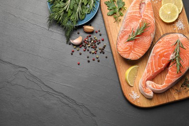Photo of Fresh salmon and ingredients for marinade on black table, flat lay. Space for text