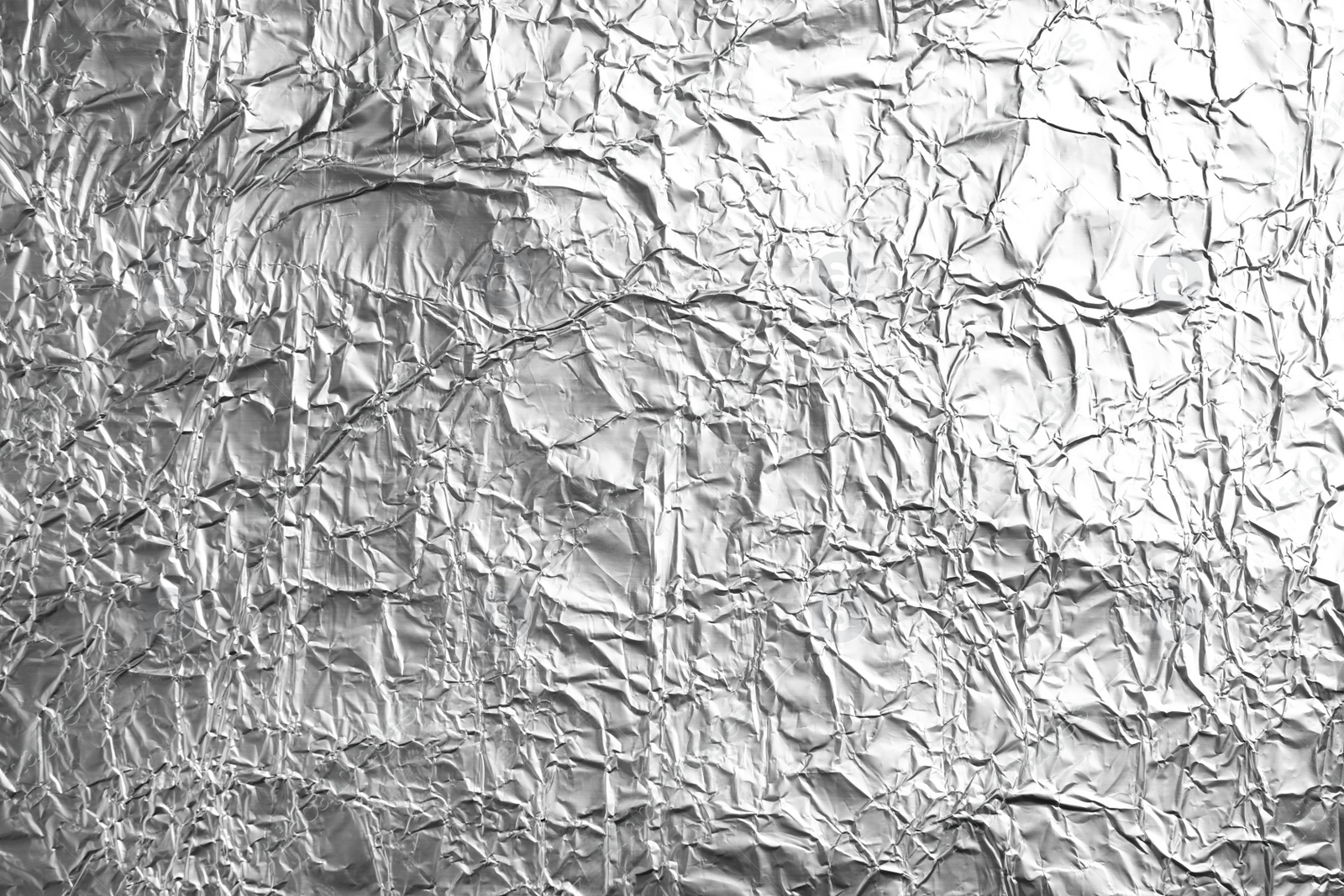 Photo of Crumpled silver foil as background, closeup view