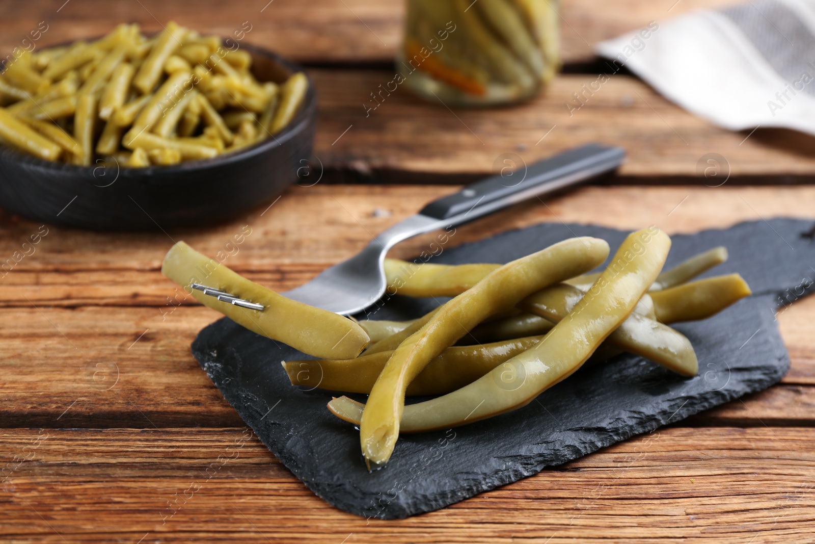 Photo of Delicious canned green beans on wooden table