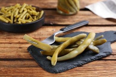 Photo of Delicious canned green beans on wooden table