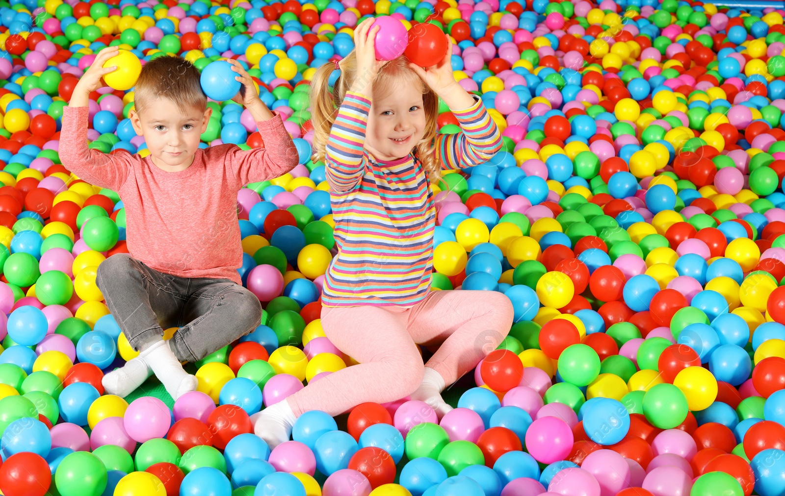 Photo of Cute children playing in ball pit indoors