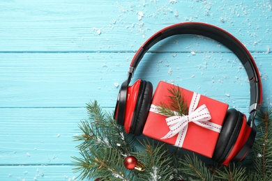 Flat lay composition with headphones on blue wooden background, space for text. Christmas music concept