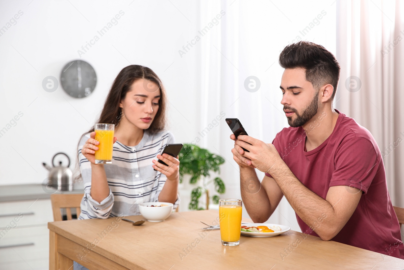 Photo of Young couple addicted to smartphones at home