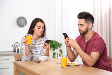 Photo of Young couple addicted to smartphones at home