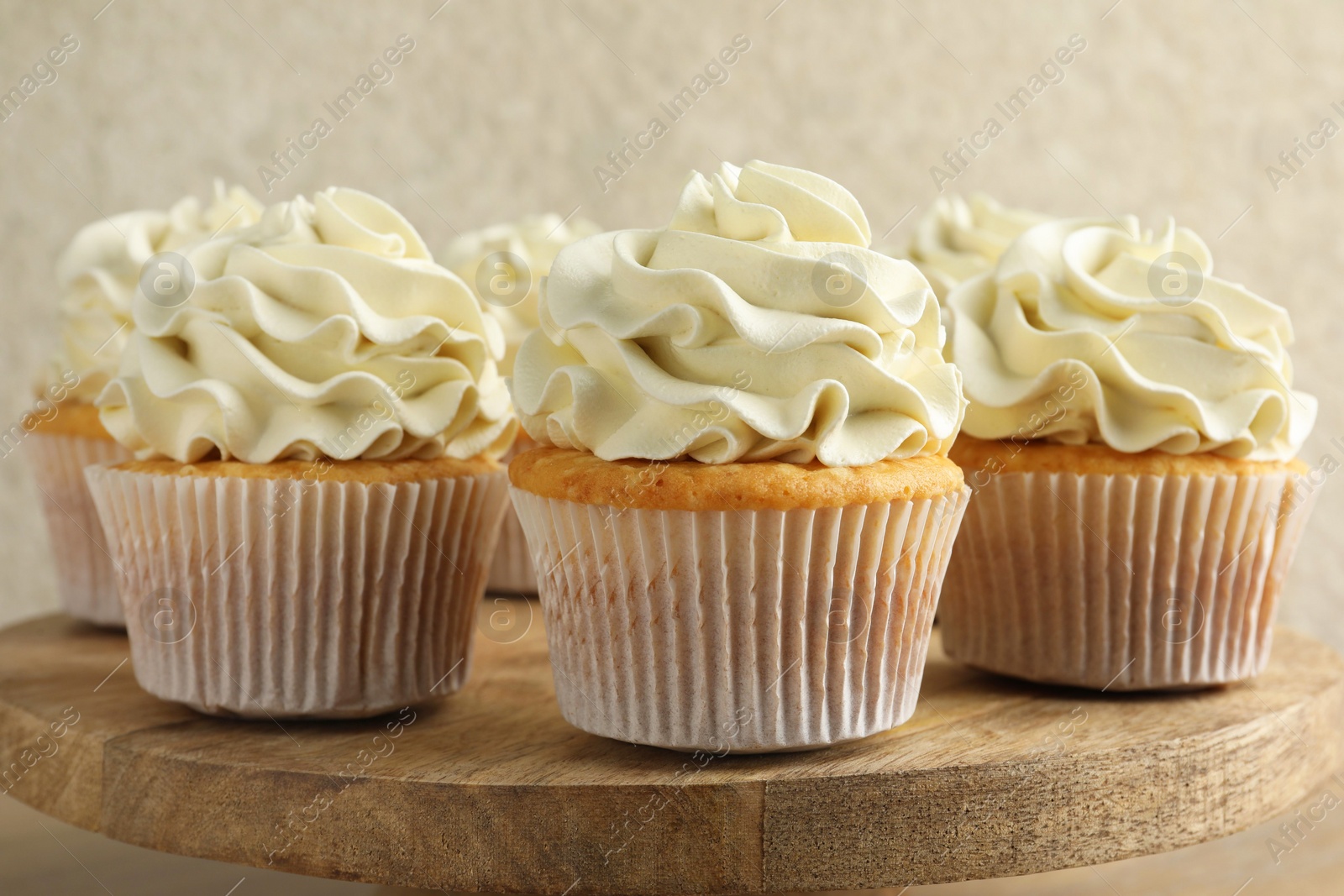 Photo of Tasty vanilla cupcakes with cream on table, closeup