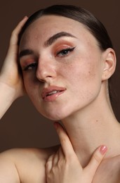 Portrait of beautiful woman with fake freckles on brown background