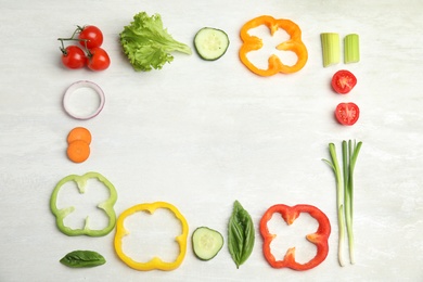 Photo of Frame made with fresh salad ingredients on white wooden table, flat lay. Space for text