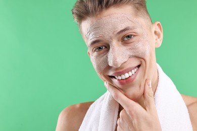 Photo of Handsome man with facial mask on his face against green background. Space for text