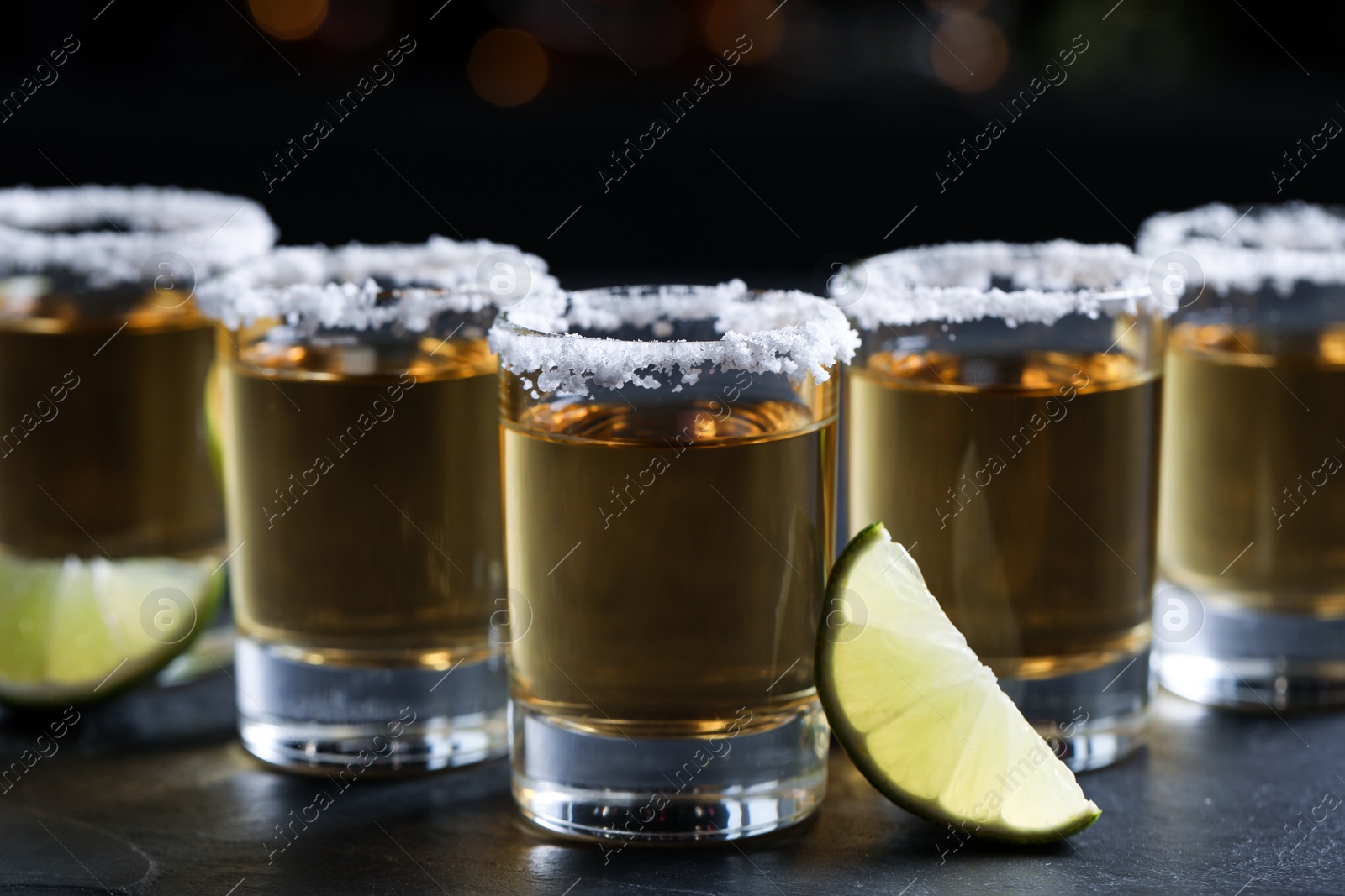 Photo of Mexican Tequila shots, lime slices and salt on bar counter