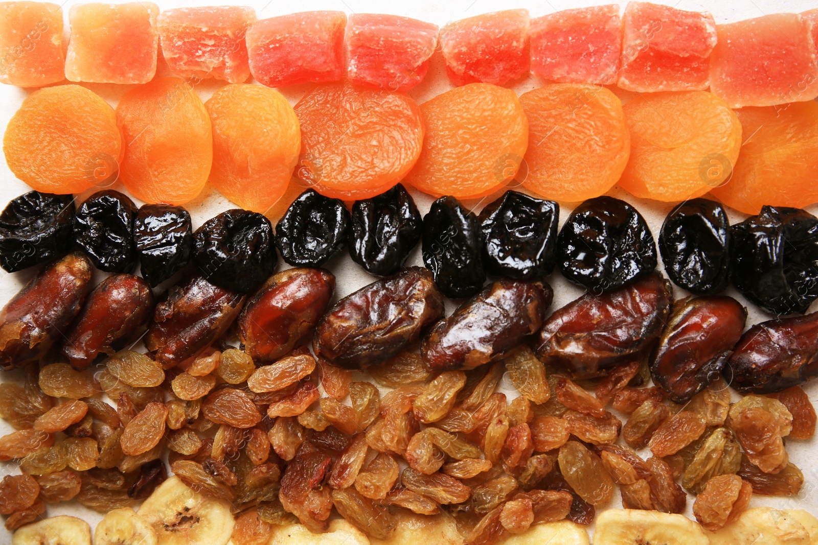 Photo of Different tasty dried fruits as background, top view