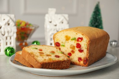 Photo of Delicious cake with candied fruits and Christmas decor on light grey table