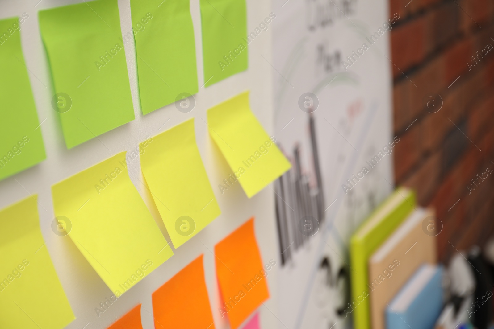 Photo of Blank colorful paper notes on white board, closeup