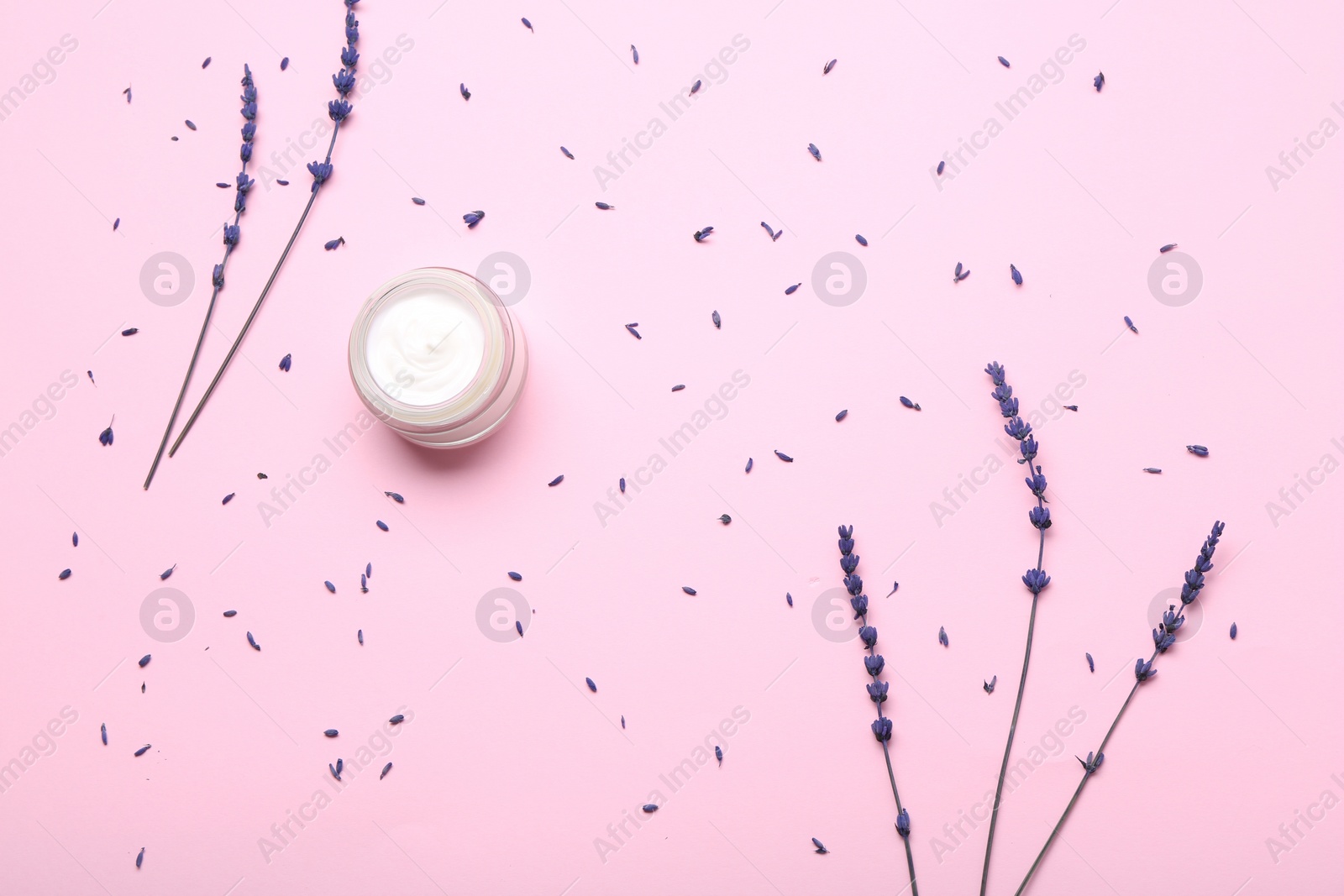 Photo of Jar of cream and lavender flowers on pink background, flat lay