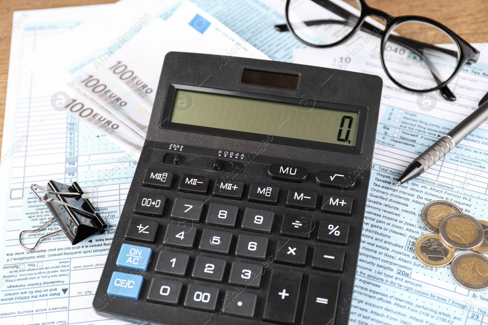 Photo of Tax accounting. Calculator, documents, money, glasses and pen on table, closeup