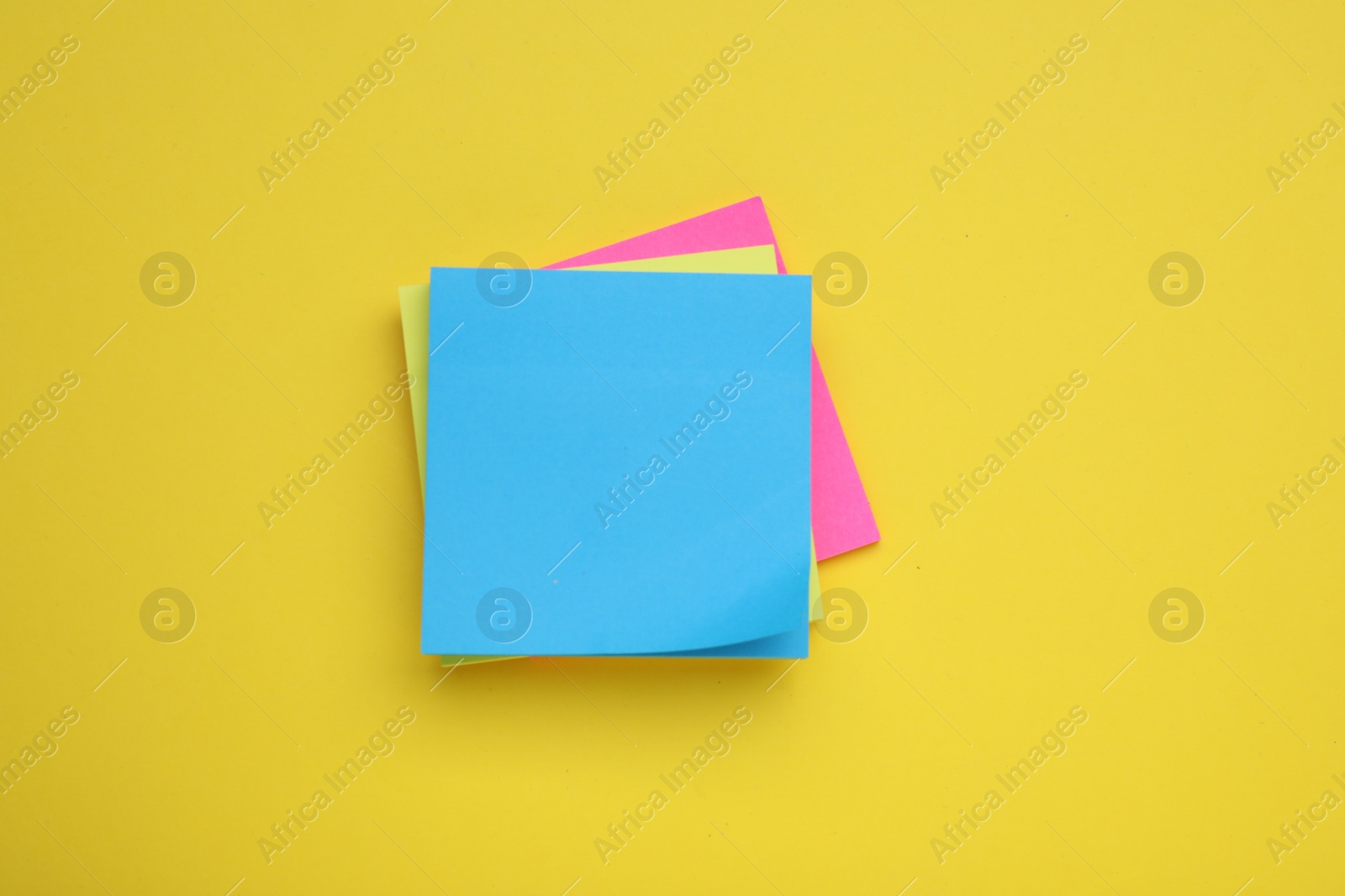 Photo of Paper notes on yellow background, top view