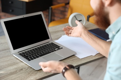 Photo of Man using video chat on laptop in home office, closeup. Space for text