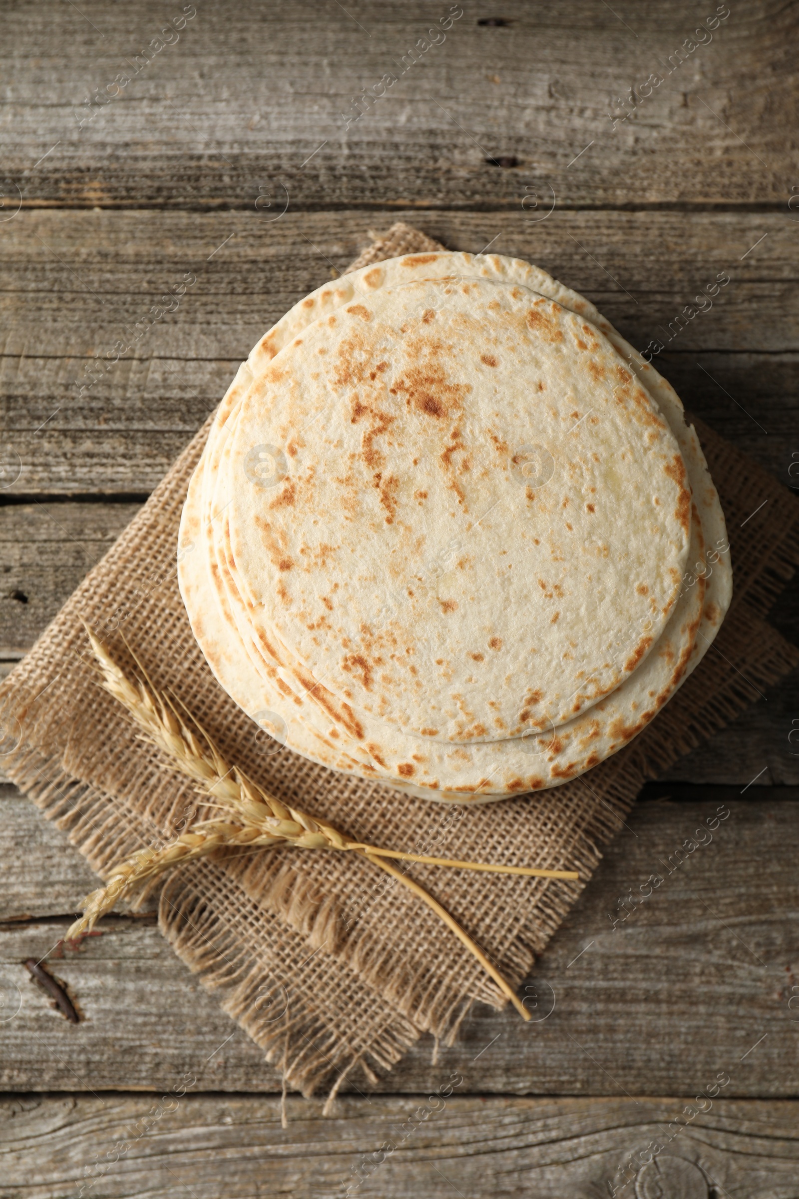 Photo of Tasty homemade tortillas and spikes on wooden table, top view