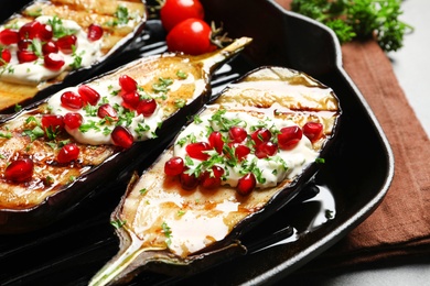 Photo of Grill pan with fried eggplants on table, closeup