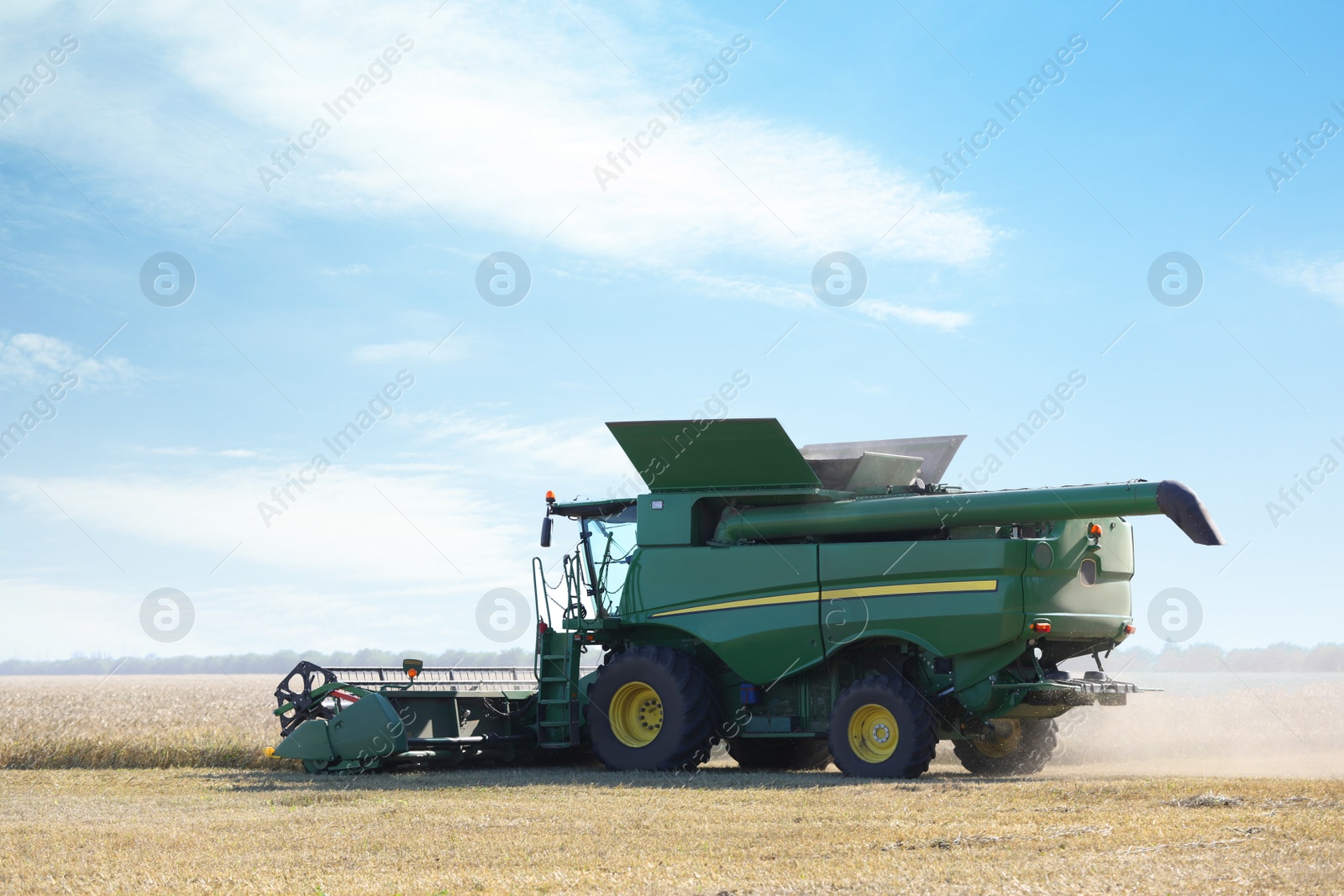 Photo of Modern combine harvester working in agricultural field