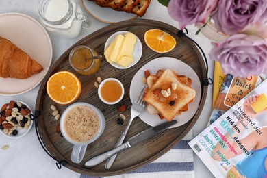 Tray with tasty breakfast on white table, flat lay