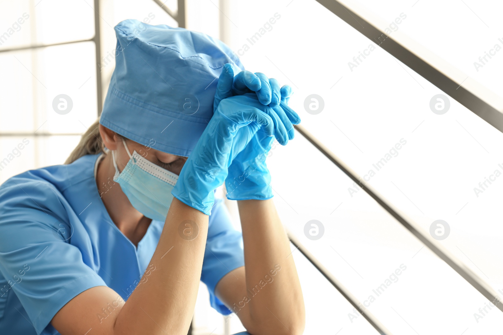 Photo of Exhausted doctor indoors. Stress of health care workers during COVID-19 pandemic