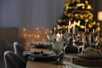 Photo of Christmas table setting with festive decor and dishware indoors