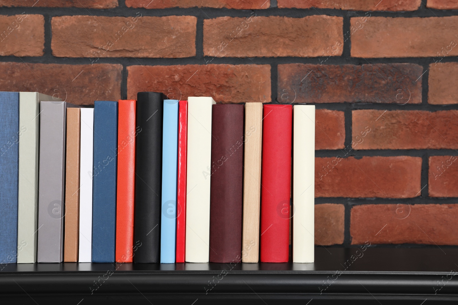 Photo of Many different hardcover books on black console table