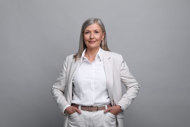 Portrait of beautiful senior woman on grey background