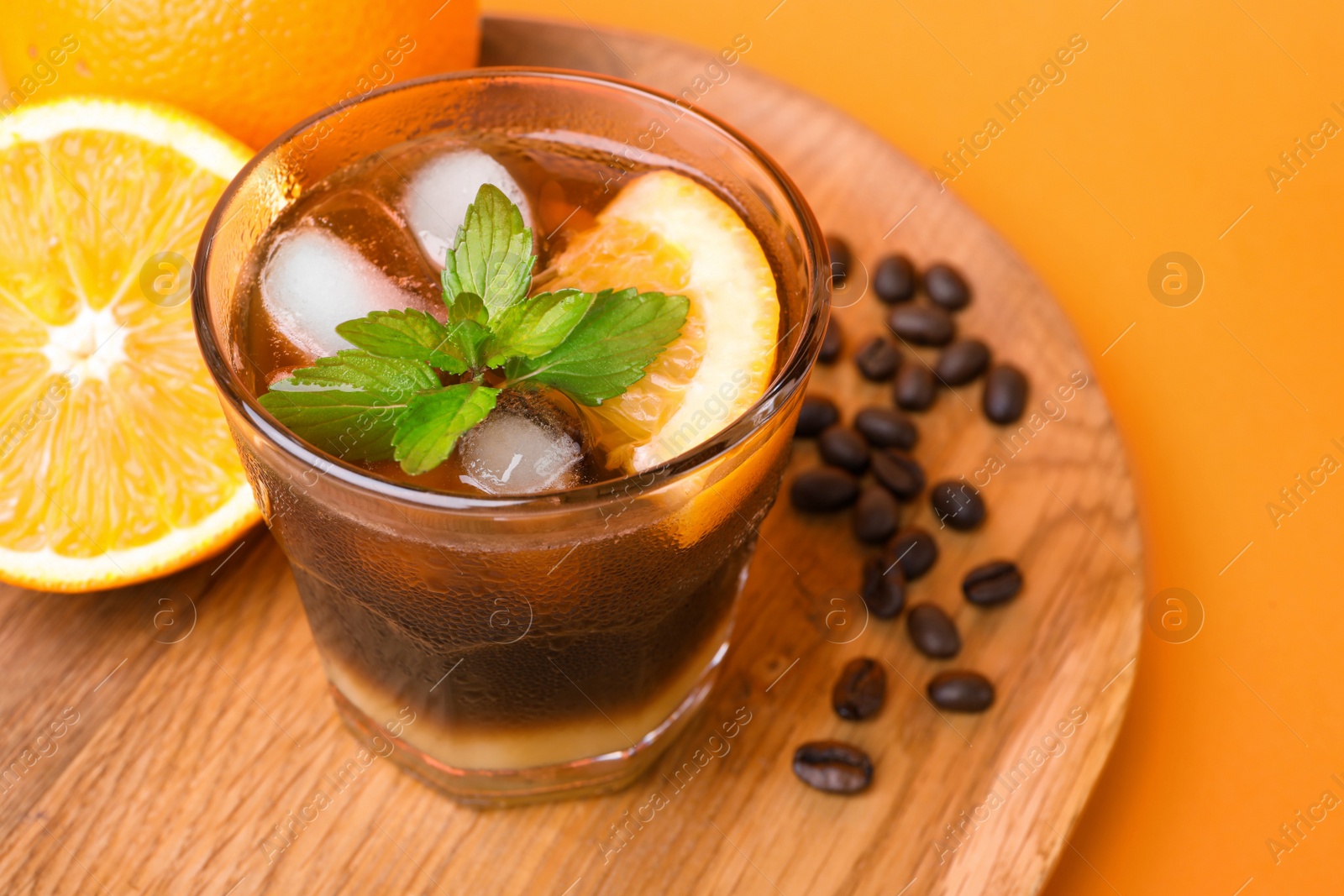 Photo of Tasty refreshing drink with coffee and orange juice on bright color background